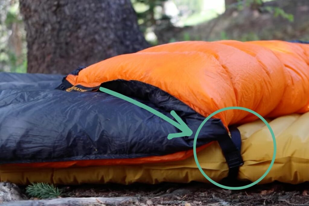a camping quilt attached to a sleeping pad